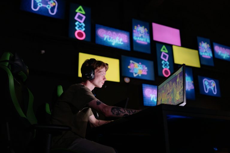 A focused gamer plays e-sports in a neon-lit room, surrounded by digital screens.